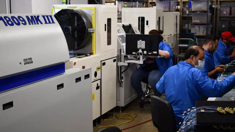 Technicians at the reflow oven on the SMT line